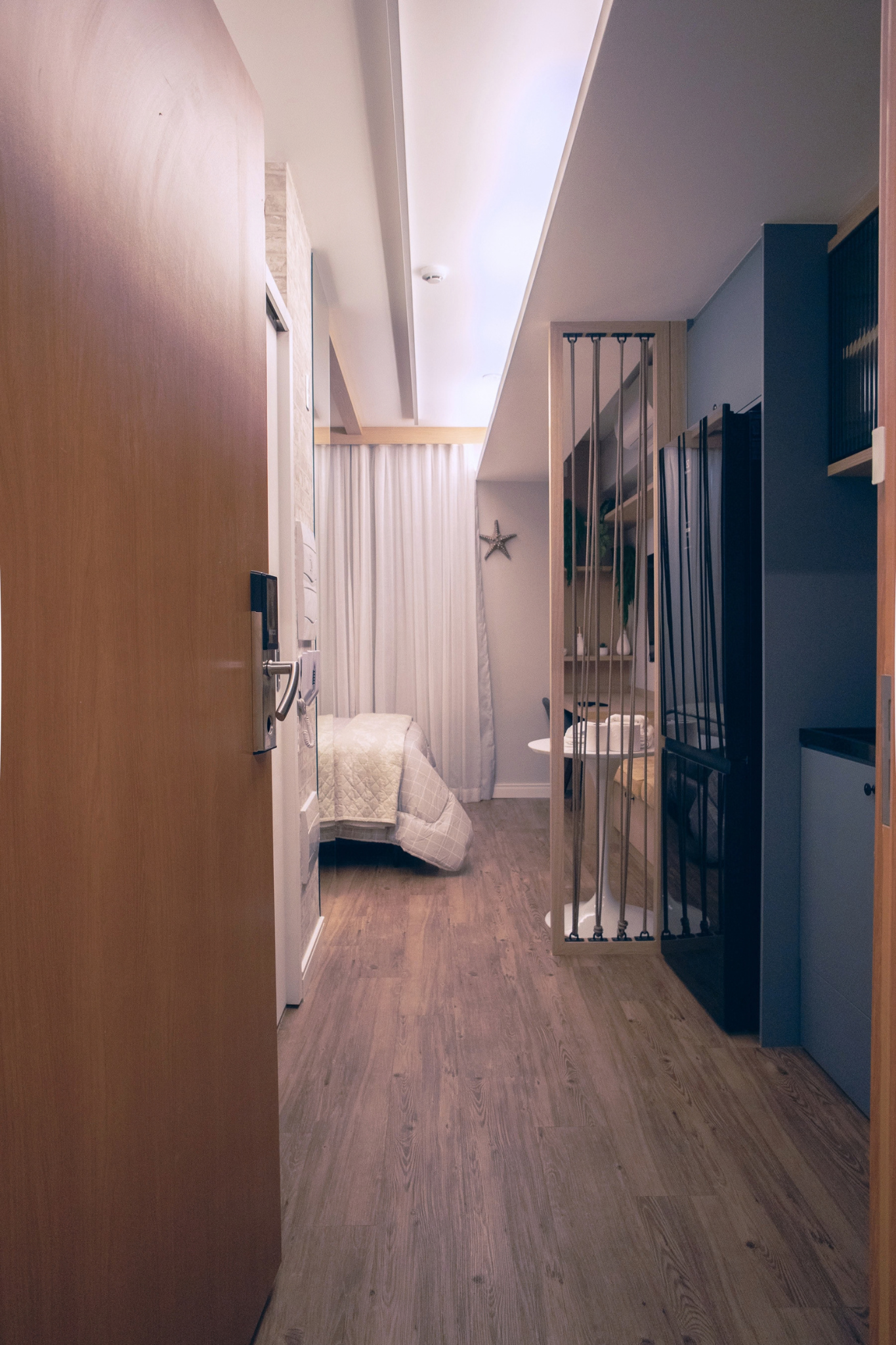 Studio de 24,67 m² reformado pela Bewild no Terrae, em Pinheiros: sala integrada com cozinha e marcenaria planejada
