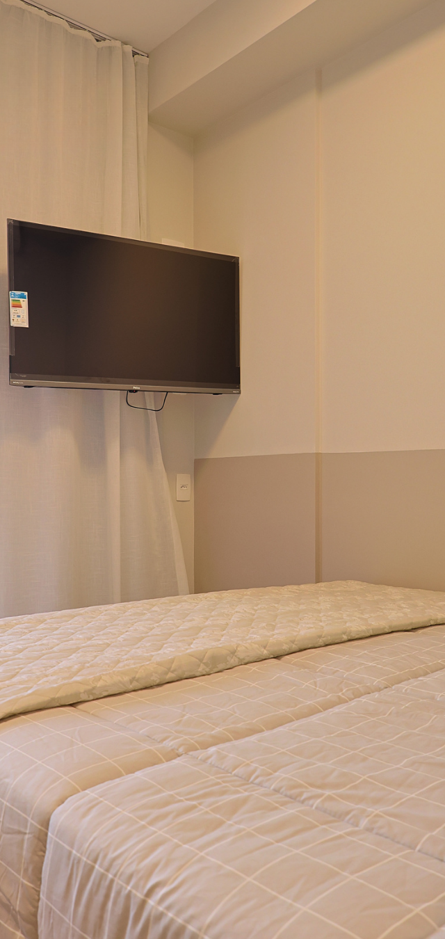 Obra pronta: Cama de casal com TV na parede e janela com cortina branca