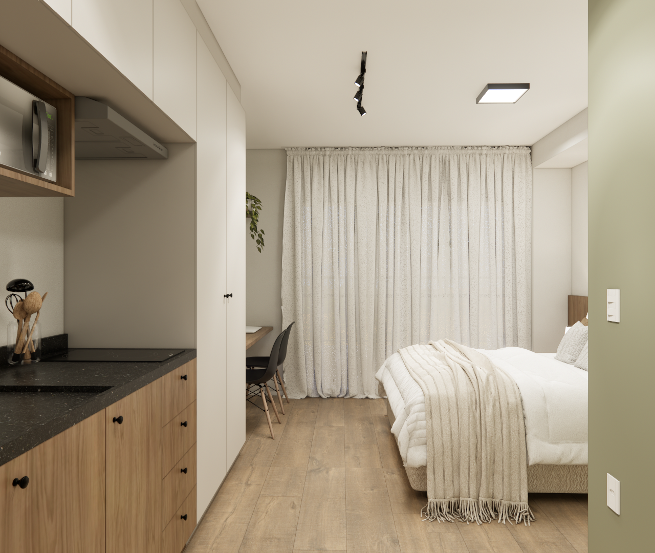 Cozinha com armários inferiores amadeirados, módulos superiores claros, bancada preta e cama próxima à cortina branca.