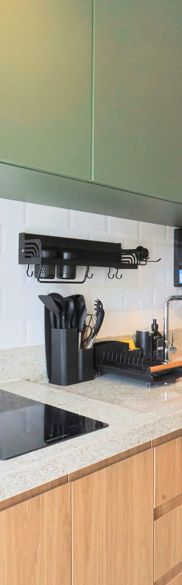 Obra pronta: Cozinha com armários verdes e de madeira, cooktop, cuba inox e revestimento metrô branco