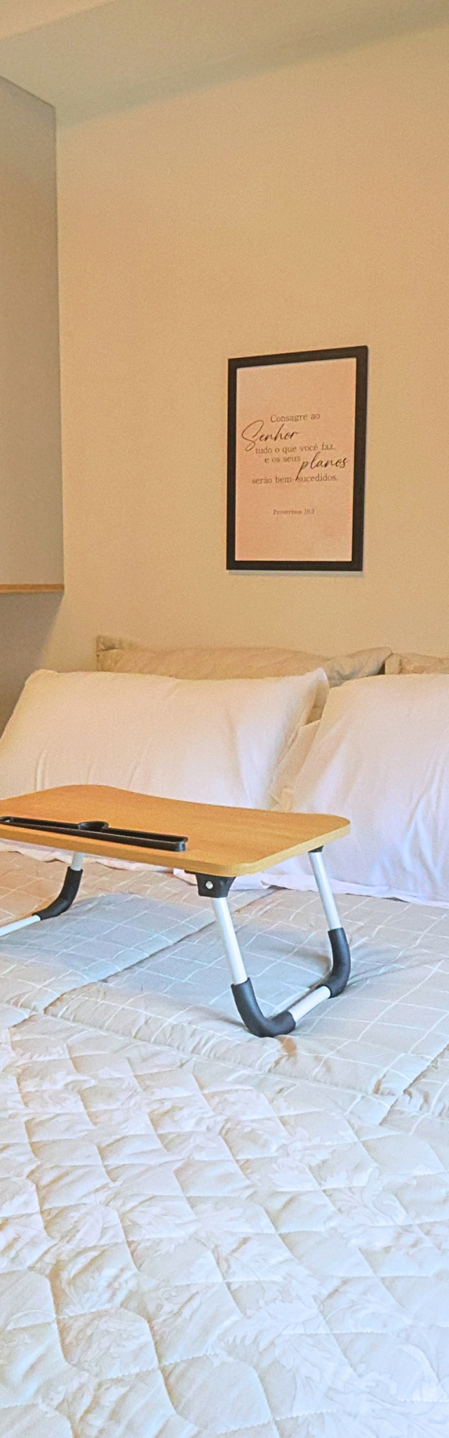 Obra pronta: Cama de casal com mesinha dobrável de madeira e dois quadros com frases na parede