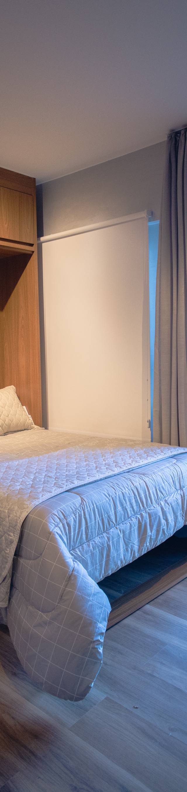 Obra pronta: Cama de casal com marcenaria de madeira e porta de vidro para a varanda com cortina