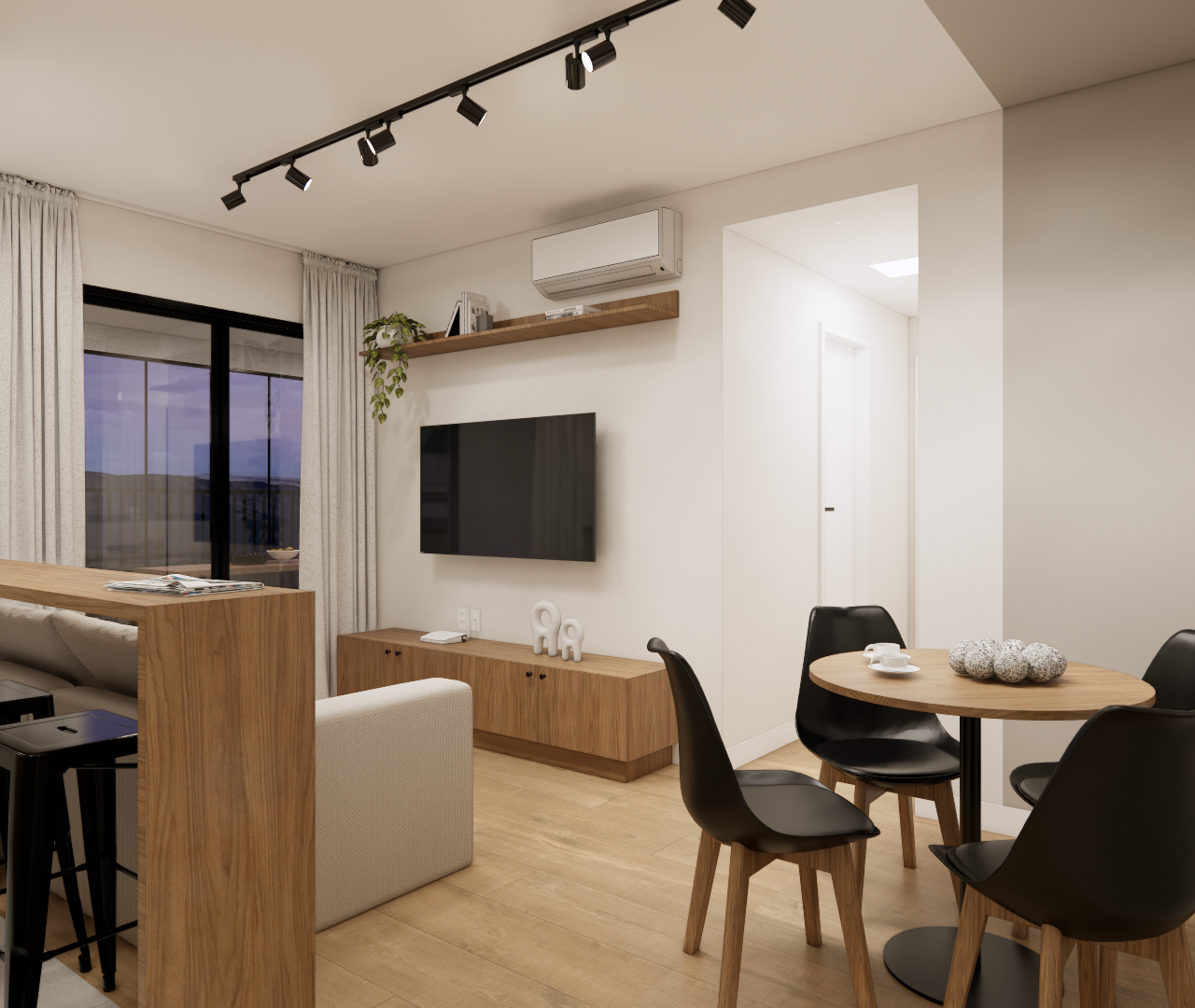 Sala com sofá claro, mesa redonda, bancada amadeirada com banquetas e cozinha compacta integrada ao espaço de estar.