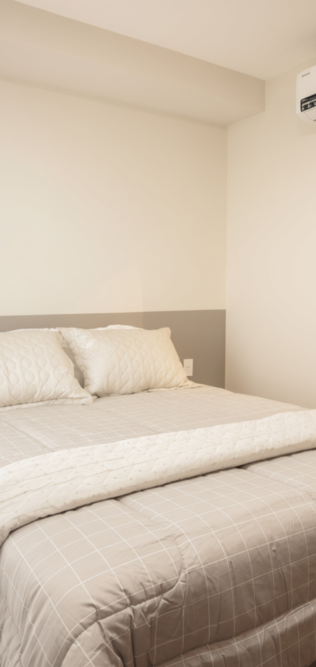 Obra pronta: Cama de casal com meia-parede cinza, espelho orgânico de moldura preta e ar-condicionado