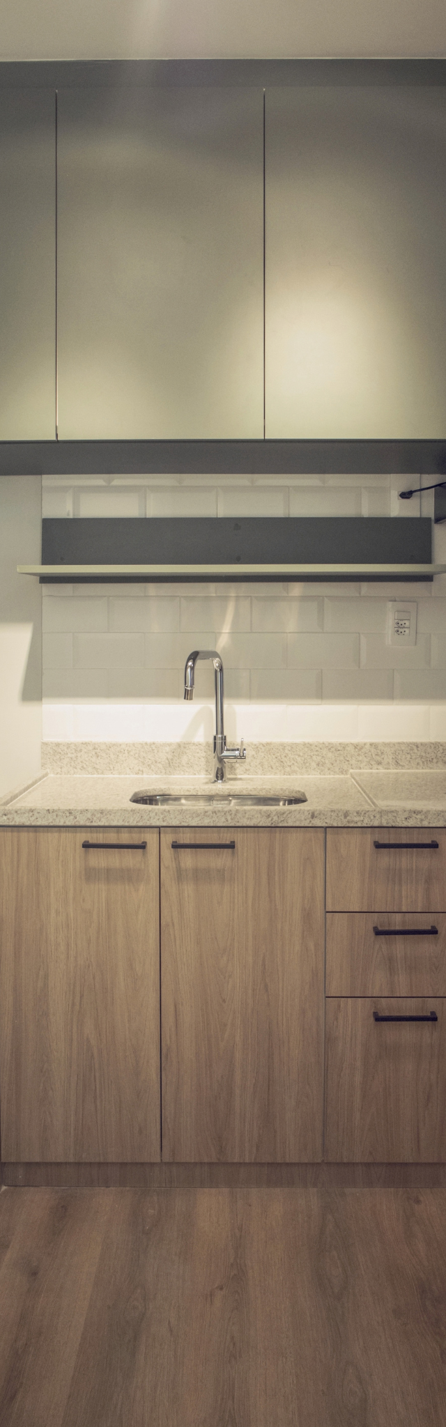 Obra pronta: Cozinha com gabinete de madeira, bancada de granito claro, metrô branco e geladeira inox