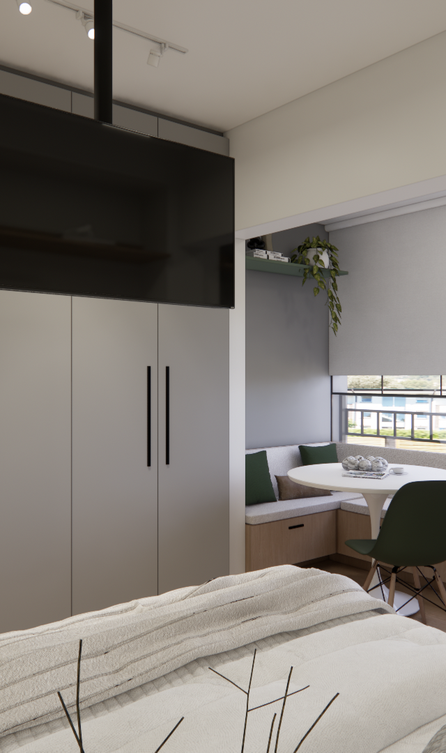Render 3D de estúdio com armários cinzas, TV suspensa, mesa redonda com banco de madeira e almofadas verdes junto à janela