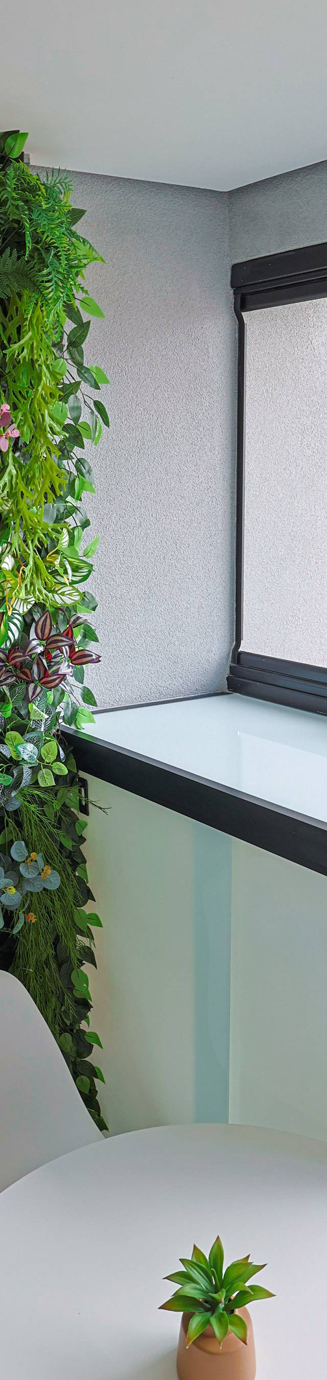 Obra pronta: Canto da varanda com jardim vertical, armário de vidro e mesa redonda com planta