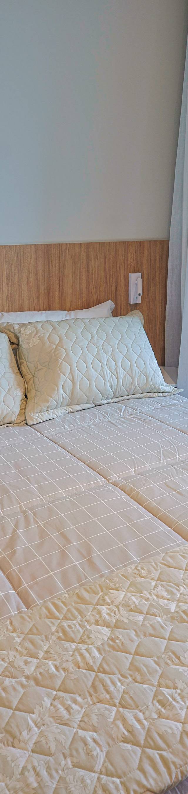 Obra pronta: Cama de casal com cabeceira de madeira ao lado da porta da varanda com jardim vertical