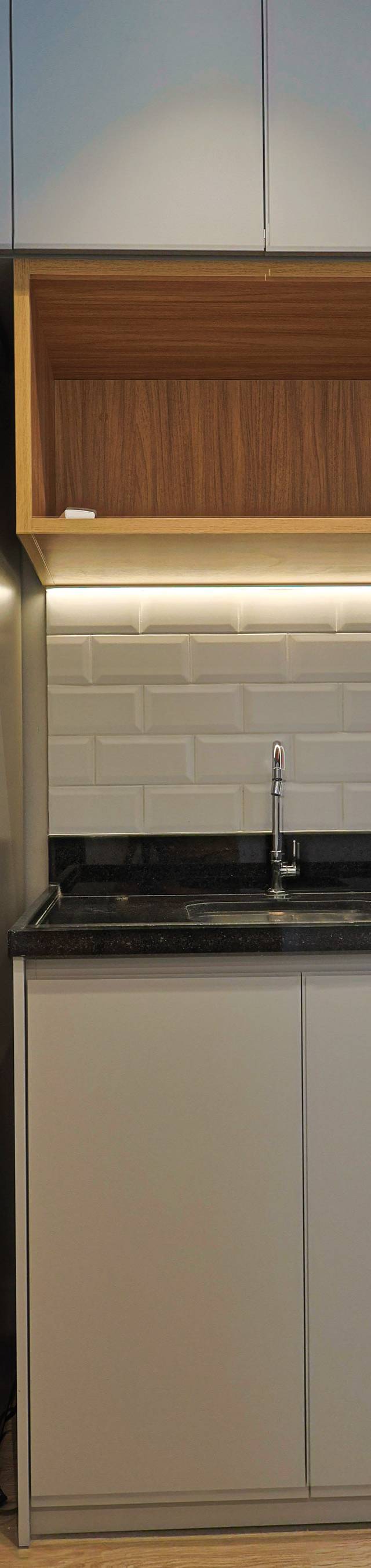 Obra pronta: Cozinha com armários claros, nicho de madeira com luz embutida, metrô branco e geladeira inox